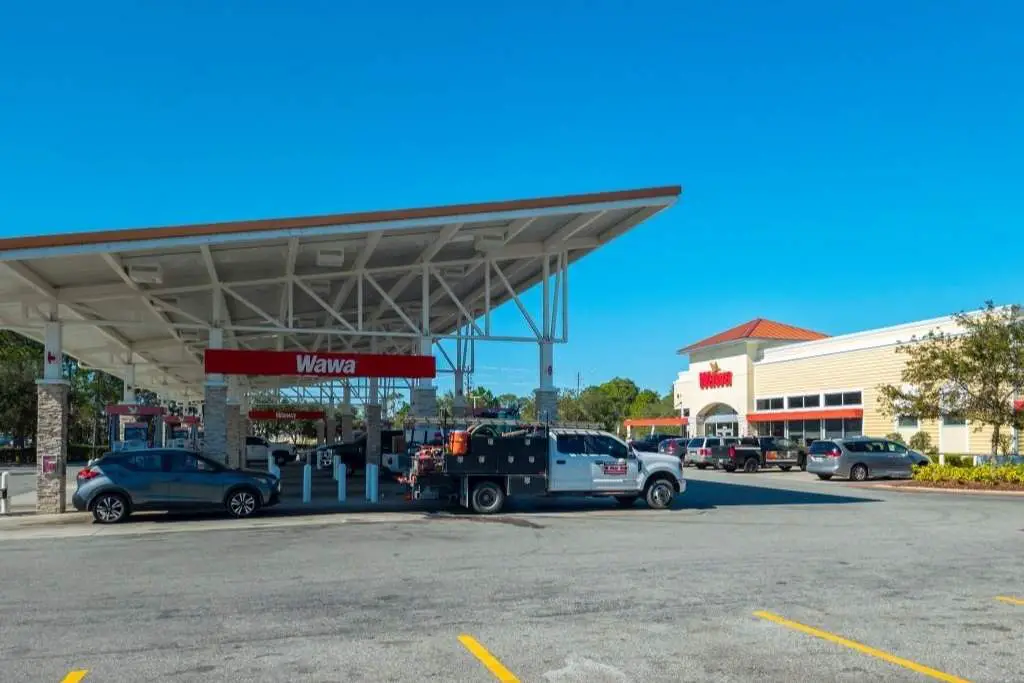 wide view of wawa convenience store and gas station with cars refueling