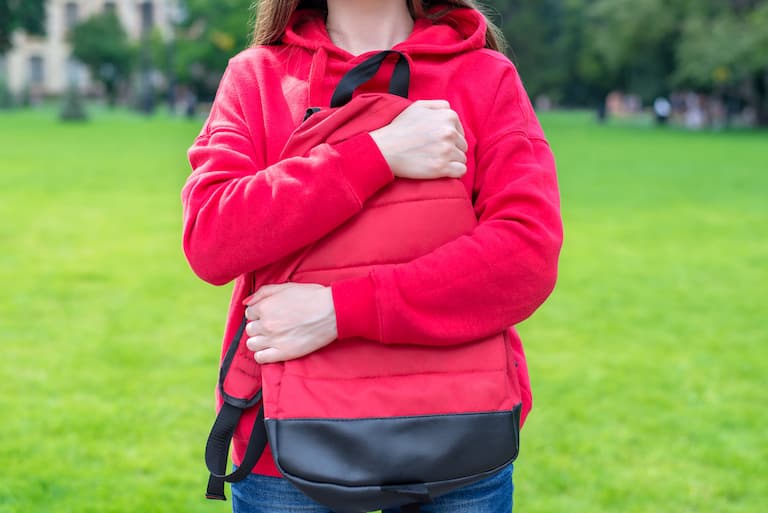 person hugging with two hands her satchel