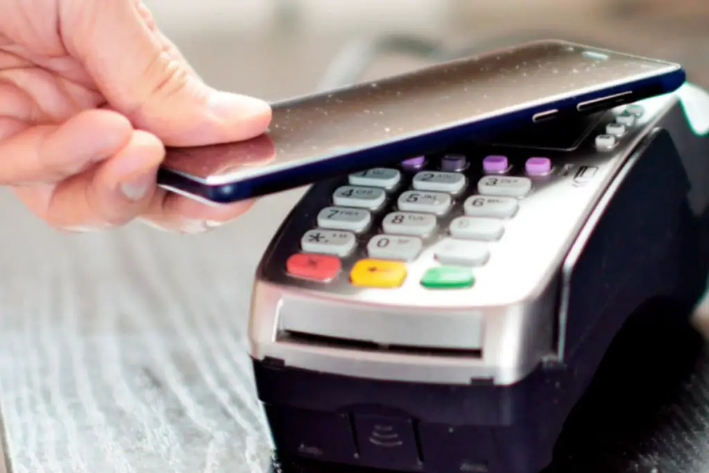 hand using mobile phone to pay with credit card