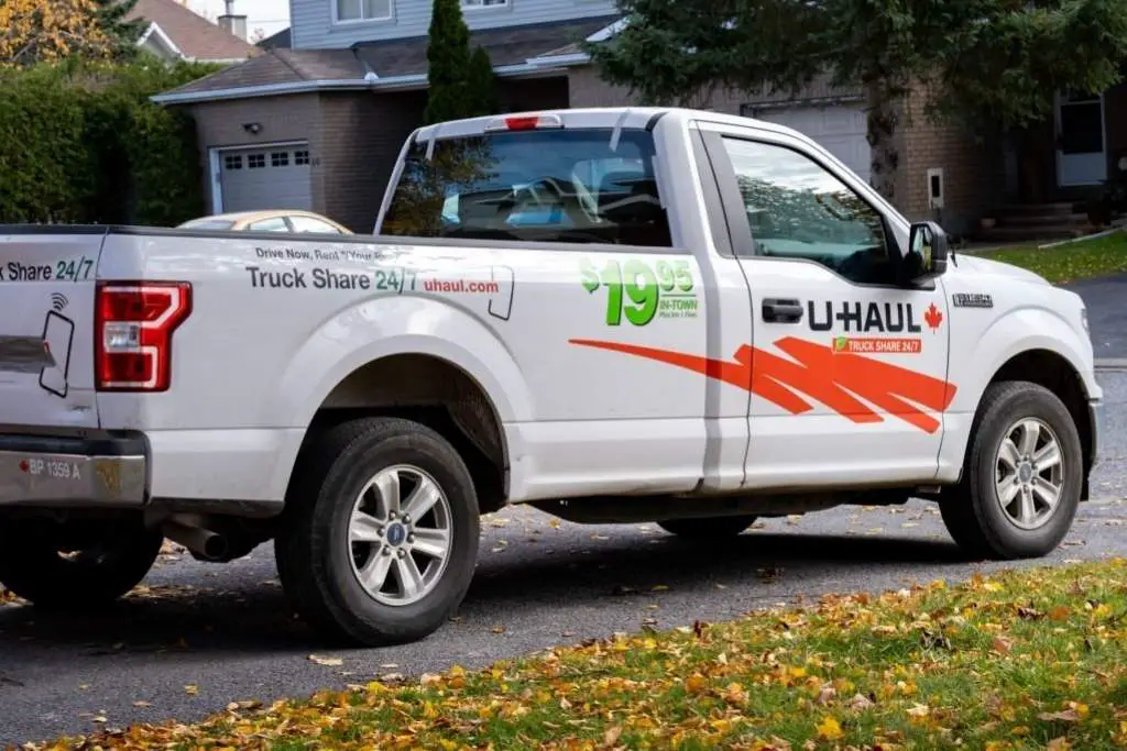 a U-Haul rental pick-up truck parked in a suburban driveway